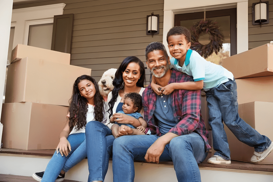 A family sitting on the steps of their home