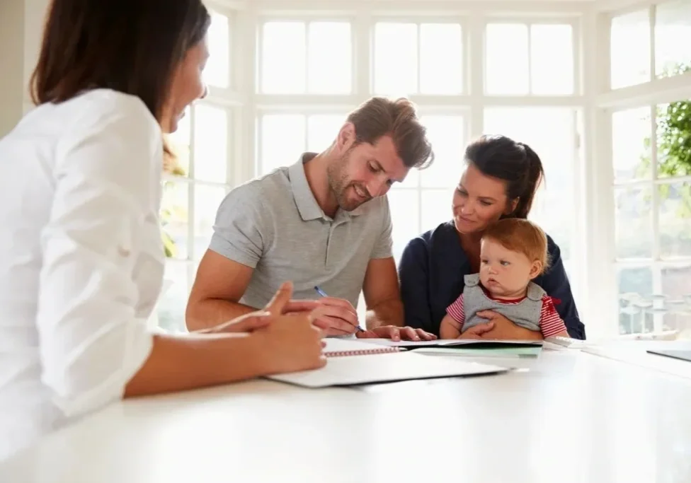 A family sitting at the table with papers and pens